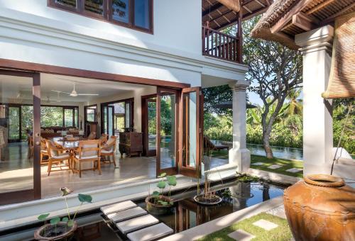 an outdoor dining area with a pool and a house at Villa Perle an Idyllic Luxury Retreat in Karangasem