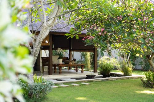 a garden with a bench in the middle of a yard at Villa Perle an Idyllic Luxury Retreat in Karangasem