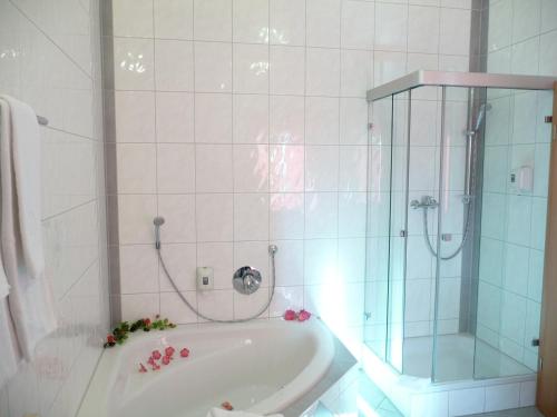 La salle de bains est pourvue d'une douche et d'une baignoire. dans l'établissement Hotel Haslbach FGZ, à Ratisbonne