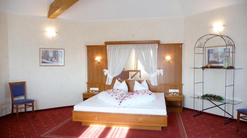 um quarto com uma cama branca e 2 cadeiras em Hotel Haslbach FGZ em Regensburg