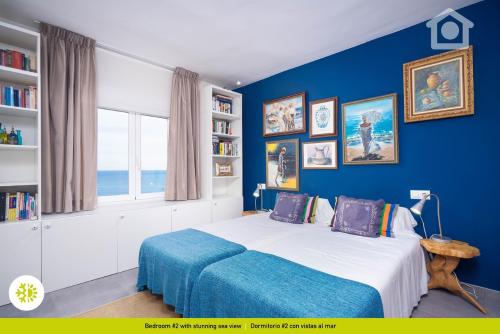 a blue bedroom with a bed and a window at Solhabitat Coll de Mar in Calpe