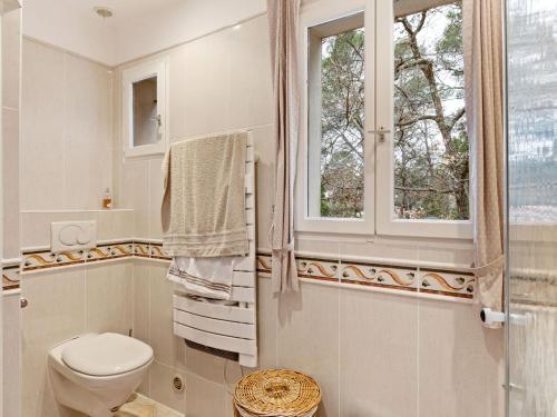 baño con aseo y ventana en Lavish Villa in Bagnols en For t with Swimming Pool, en Bagnols-en-Forêt