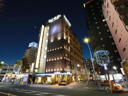 a tall building on a city street at night at Hotel Balian Resort Higashi Shinjuku in Tokyo