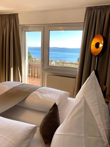 a bedroom with a bed with a view of the ocean at Hotel Landhaus Sternen in Sipplingen