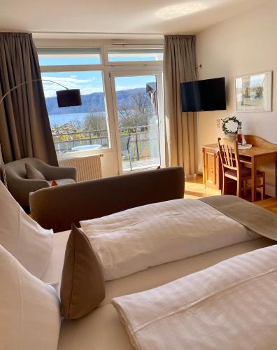 a hotel room with a bed and a table and a window at Hotel Landhaus Sternen in Sipplingen