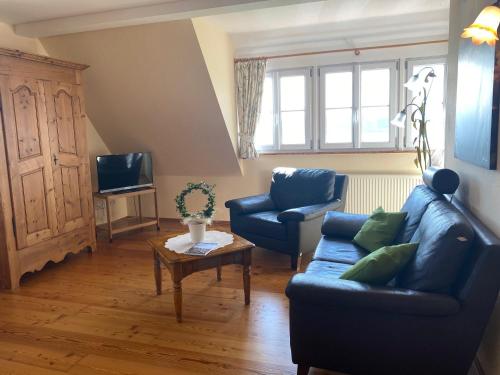 a living room with a blue couch and a table at Hotel Landhaus Sternen in Sipplingen