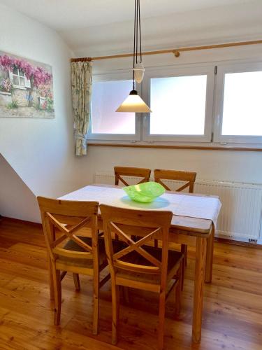 a dining room table with chairs and a green bowl on it at Hotel Landhaus Sternen in Sipplingen
