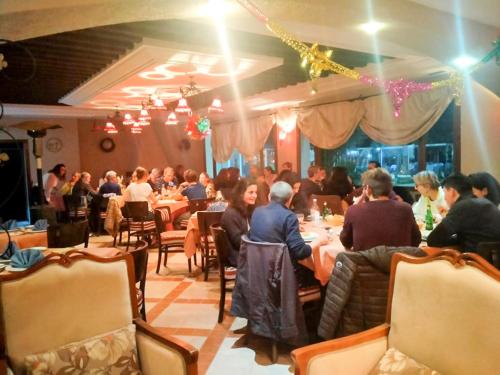 a group of people sitting at tables in a restaurant at Hotel de charme et SPA Dar El Bhar in Mezraya