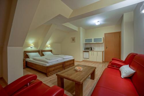a living room with a bed and a red couch at Jawor Pokoje i Apartamenty in Zakopane
