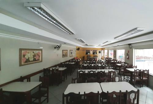 a dining room with tables and chairs in a building at Hotel do Papa in Aparecida