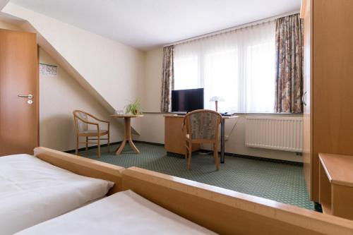 Habitación de hotel con cama y escritorio en Hotel am Schloß en Schwerin