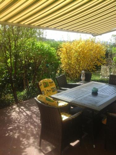 a patio with a table and chairs under a roof at Reitbergs Nest in Eugendorf