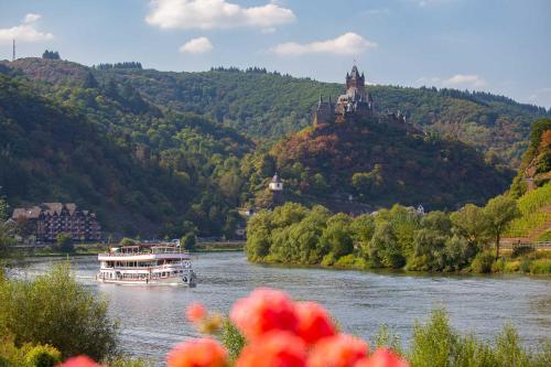 a boat on a river with a castle on a hill at Landhaus Heimisch Bed & Breakfast in Geisfeld