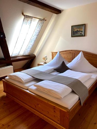 a large wooden bed in a room with a window at Hotel Landhaus Sternen in Sipplingen