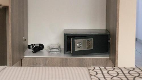 a small microwave in a shelf next to a bed at Pravi Hotel in Eleftheroúpolis