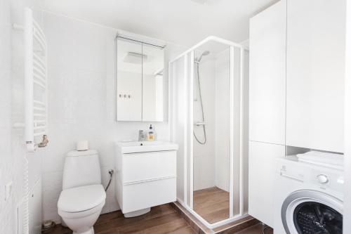a white bathroom with a toilet and a shower at 3 Bedroom Apartment 24h self check in, free parking, Ac, fireplace in Vilnius