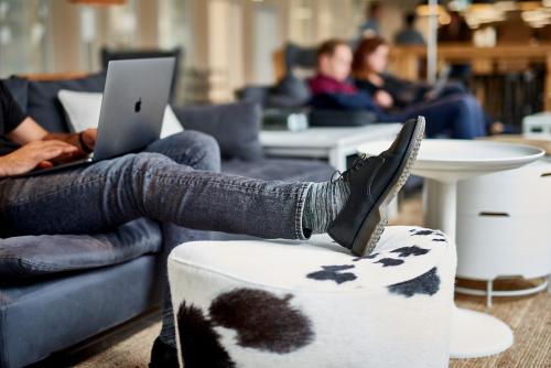 a person sitting on a couch with their feet on a ottoman at IKEA Hotell in Älmhult