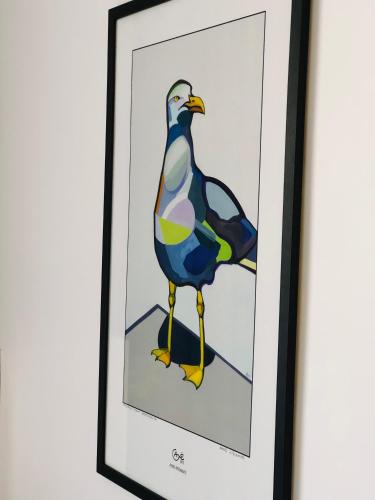 a painting of a bird in a black frame at Astos Vila in Palanga