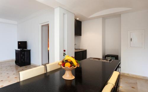 a kitchen with a table with a bowl of fruit on it at Djerba Aqua Resort in Midoun