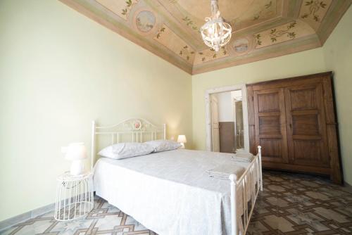 a bedroom with a white bed and a chandelier at Aria di Vico Aparthotel in Vico del Gargano