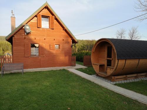 a large wooden house with a round building at Domki Krótki Szpic in Istebna
