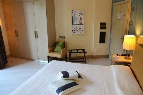 a bedroom with a white bed with two pillows on it at Hotel Riviera dei Fiori in San Lorenzo al Mare