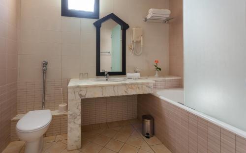 a bathroom with a sink and a toilet and a tub at Djerba Aqua Resort in Midoun