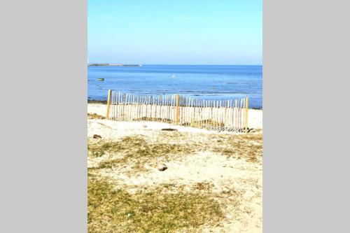 a fence on the beach with the ocean in the background at Stilren studiolägenhet på 20 kvm nära havet och centrum! Stationsterrassen 7 in Båstad