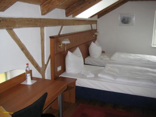 1 Schlafzimmer mit 2 Betten, einem Schreibtisch und einem Tisch in der Unterkunft Komfort Apartmenthaus Haslbach FGZ in Regensburg