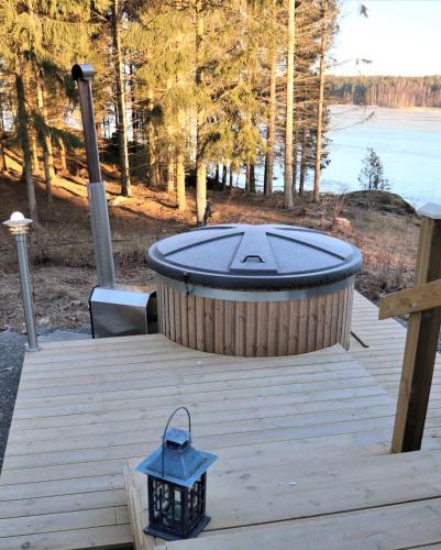 a jacuzzi tub sitting on a wooden deck at Hattapukki - Villa Himpula in Sysmä