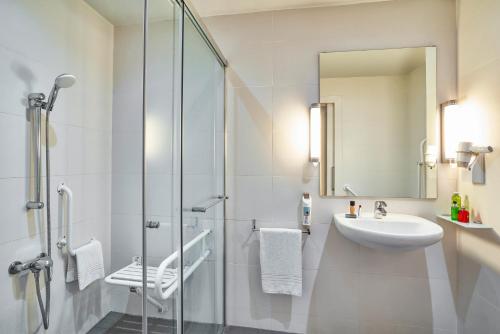 a white bathroom with a sink and a shower at Ibis Barcelona Meridiana in Barcelona