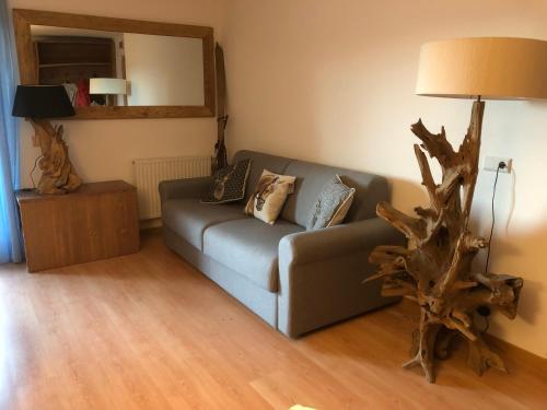 ein Wohnzimmer mit einem Sofa und einem Ast in der Unterkunft Appartamento Incanto in Olang