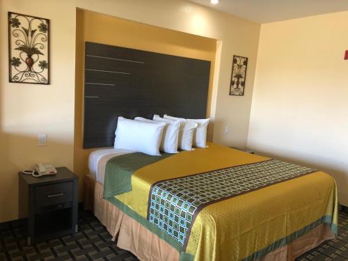 Habitación de hotel con cama grande con almohadas blancas en Homegate Inn & Suites West Memphis, en West Memphis