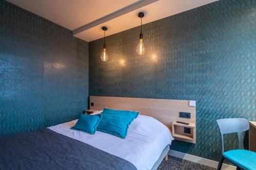 a bedroom with a bed with blue walls at Sous Les Pins in Étoile-sur-Rhône