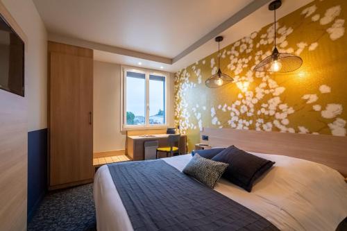 a bedroom with a bed and a desk and a window at Sous Les Pins in Étoile-sur-Rhône