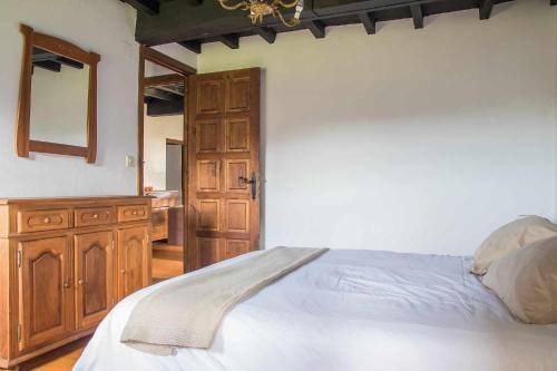Un dormitorio con una cama grande y un armario de madera. en Casa de Aldea Casa de Isidoro, en Linares