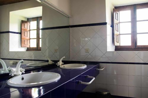 a bathroom with two sinks and a mirror at Casa de Aldea Casa de Isidoro in Linares