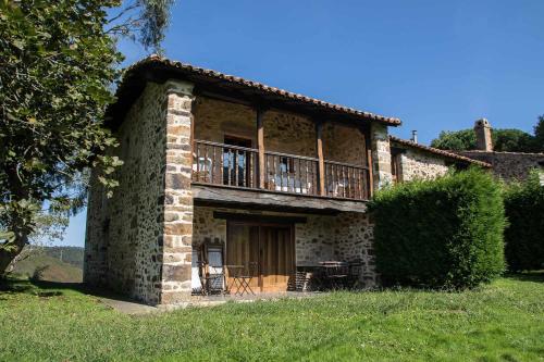 Casa de Aldea Casa de Rubio في Linares: منزل حجري كبير مع شرفة فوقه