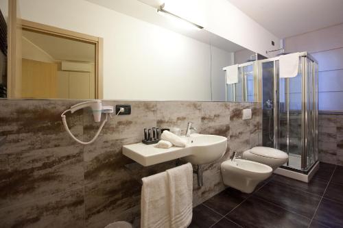 a bathroom with a sink and a toilet and a mirror at Hotel La Meridiana in Settimo Torinese