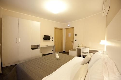 a bedroom with a bed and a desk and a television at Hotel La Meridiana in Settimo Torinese
