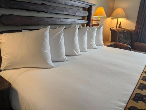 a large bed with white pillows in a hotel room at Clubhouse Inn in West Yellowstone