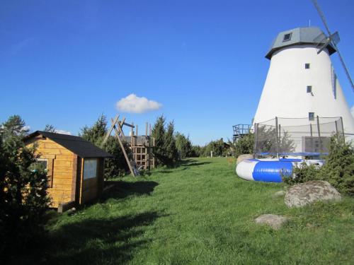 a lighthouse and a boat next to a house at Pivarootsi Holiday Village in Pivarootsi