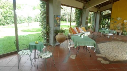 a porch with green tables and chairs and windows at Le Ninfee in Cassino