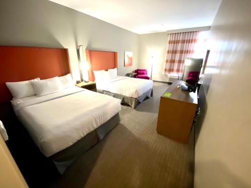 a hotel room with two beds and a desk at La Quinta by Wyndham South Jordan in South Jordan