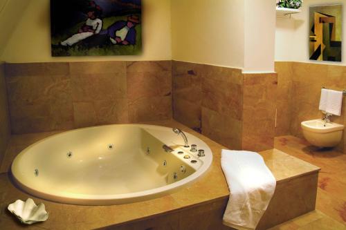 a bathroom with a large tub and a toilet at Resort Borgo San Rocco in Savoca