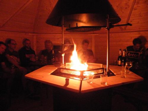 a group of people sitting around a table with a lit candle at kotas-Esprit Nordique in Balaives-et-Butz