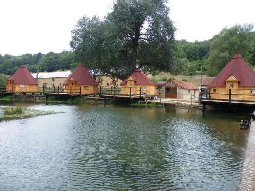 a group of houses sitting on the water at kotas-Esprit Nordique in Balaives-et-Butz