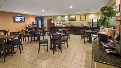 a restaurant with tables and chairs and a bar at SureStay Plus Hotel by Best Western Roanoke Rapids I-95 in Roanoke Rapids