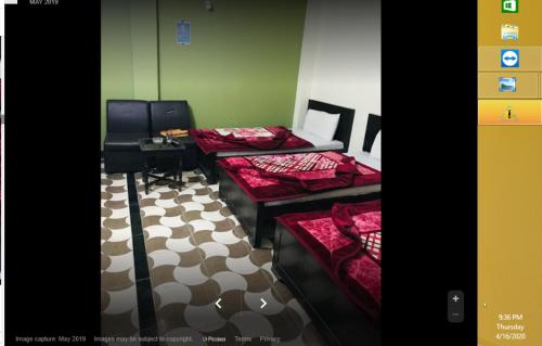a room with three beds and a checkered floor at Riverside Hotel in Mām Derai