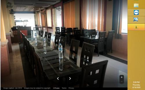 Mām Derai的住宿－Riverside Hotel，一间带长桌和椅子的用餐室